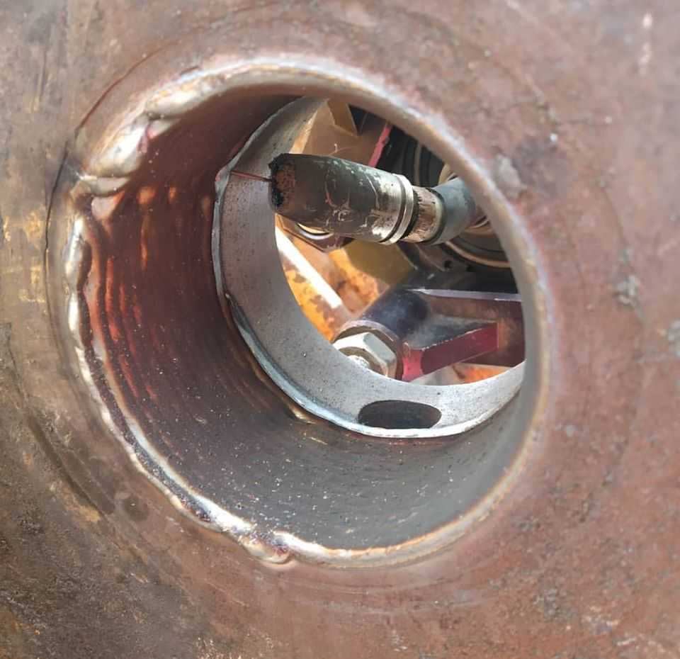 Opotřebený otvor v rameni stavebního stroje před renovací.